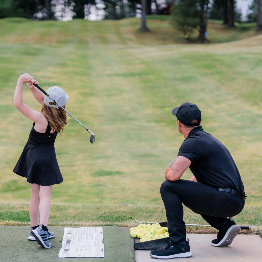 Dad teaching daughter how to hit golf ball using savvy setup golf towel