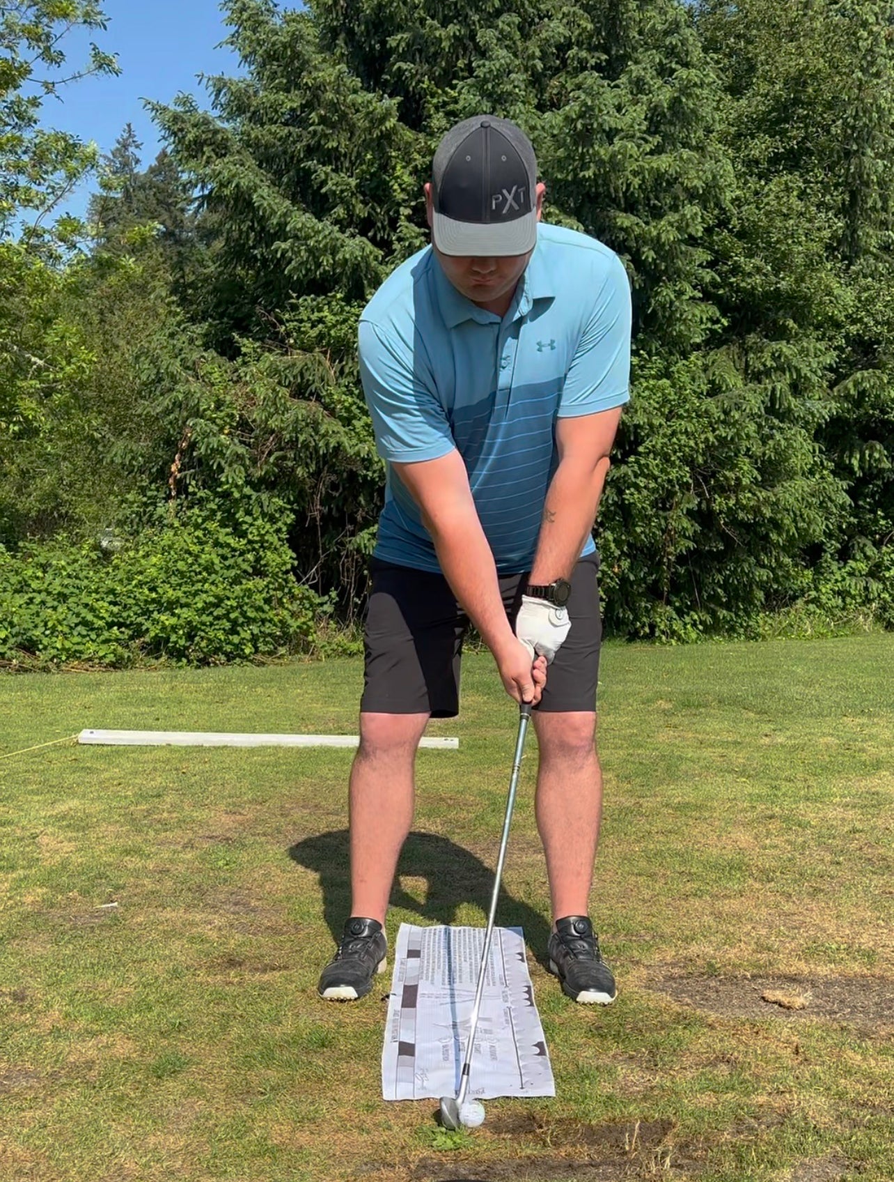 On the range with student using the savvy setup golf towel and training aid